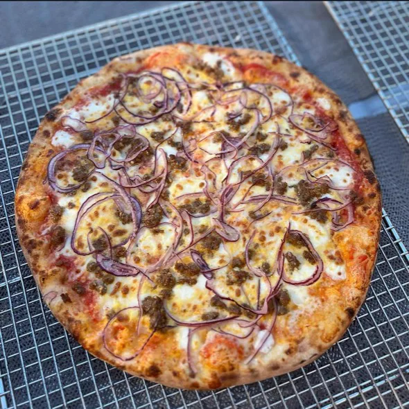 PieZ specialty pizza with sausage, red onion, and black garlic balsamic drizzle